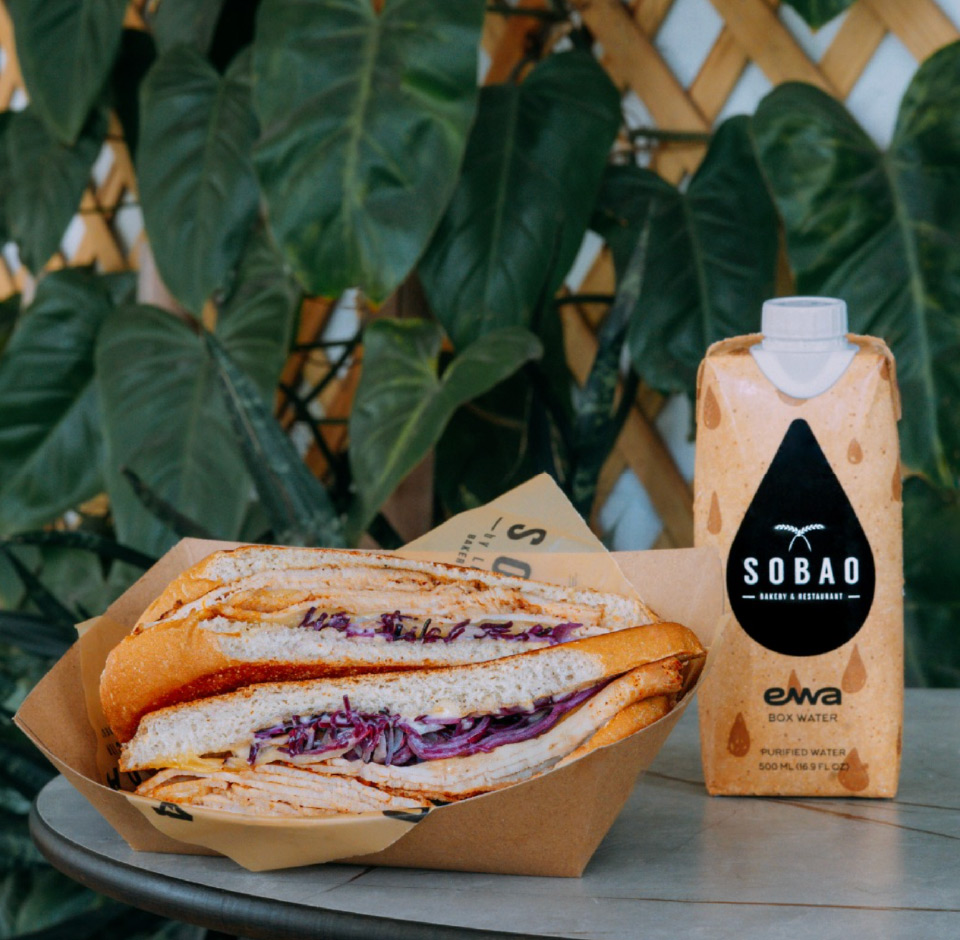 a photo of a sandwich and Sobao branded water