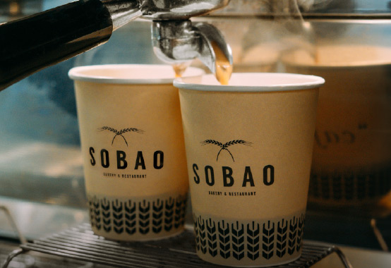 coffee being served in Sobao brand paper cups