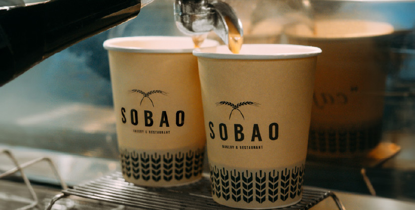 coffee being served in Sobao brand paper cups
