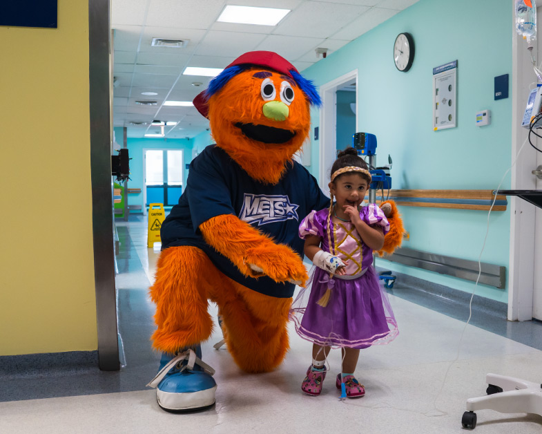 photo of the METS mascot visiting a sick child at Auxilio Mutuo Hospital